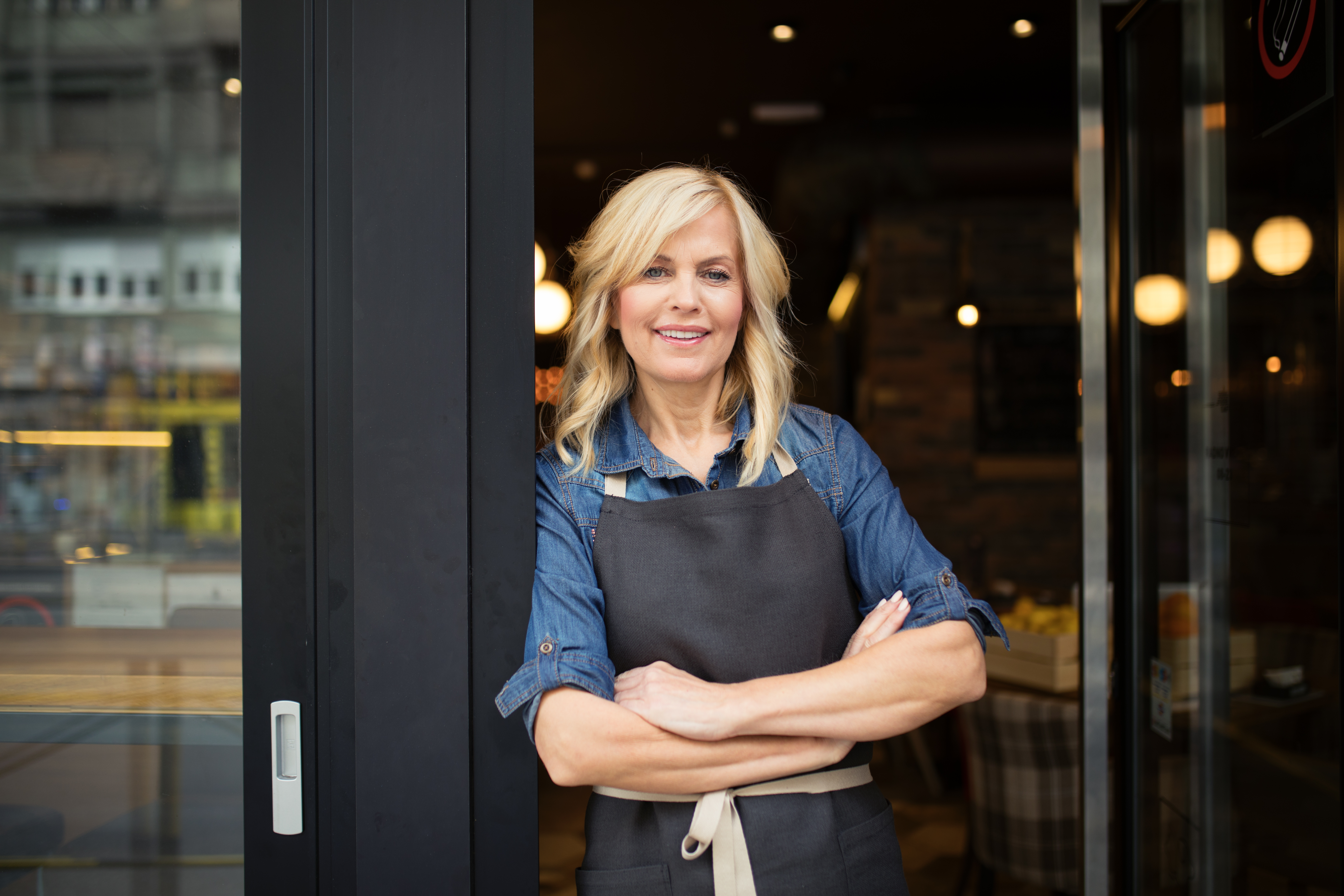 Happy business owner standing at front door